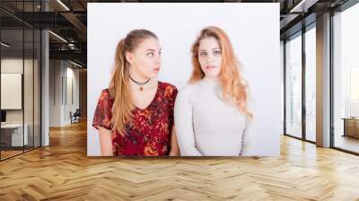 Two young beautiful girls look very surprised Wall mural