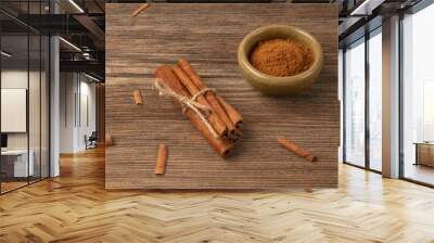 cinnamon sticks and powder on wooden table Wall mural