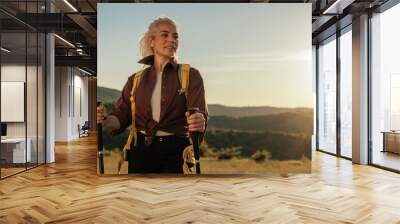 Beautiful female hiker on adventure looking at the distance Wall mural