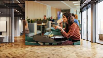 Caucasian businesswoman drink coffee at work. Wall mural