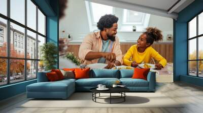 Cute afro family having lunch together at home Wall mural