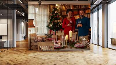 Diverse couple toasting with red wine during Christmastime Wall mural