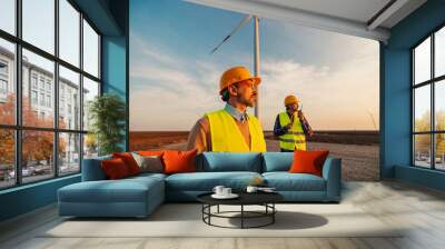 engineers standing in field with wind turbines Wall mural