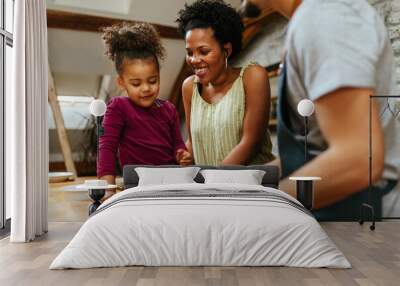 Family of three preparing food together Wall mural