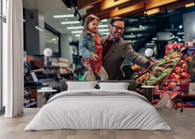 Father and daughter buying apples in grocery store Wall mural