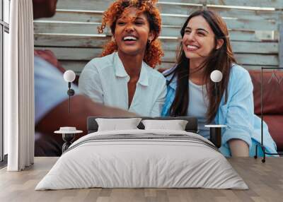 Portrait of two diverse girl friends having fun conversation Wall mural