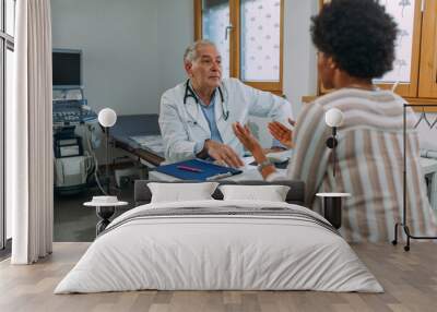 Senior doctor and his patient during examining at hospital Wall mural