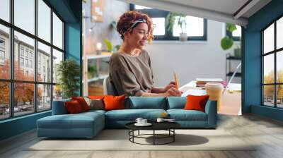 Side profile of young Hispanic business woman using laptop in the office. Wall mural