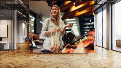 Young woman buying groceries at the supermarket Wall mural