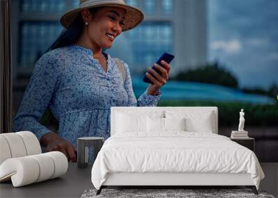 Young woman using phone while traveling in a foreign city Wall mural