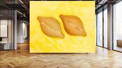 Two bolillo bread rolls on a yellow painted background Wall mural