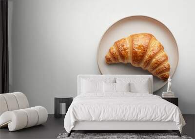 top view scene of a croissant on a plate above white background Wall mural