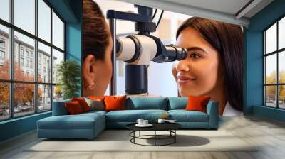 A young female eye specialist examining a patient_s retina. Wall mural