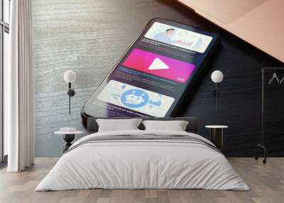 Native Online Advertising concept. Programmatic targeted ads marketing strategy. Advertising media banner block on website on the screen of the closeup smartphone lying on the wooden table Wall mural