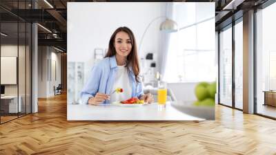 Good looking healthy woman having breakfast at table indoors. Wall mural