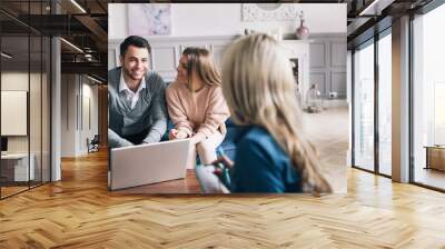 Happy young loving couple sitting together with their financial advisor. Wall mural