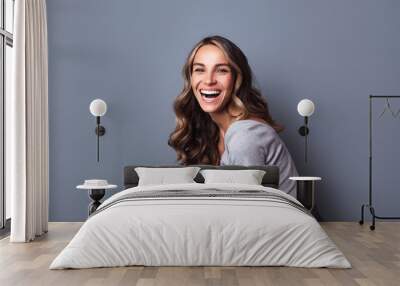 Portrait of beautiful young girl laughing on grey background. Wall mural