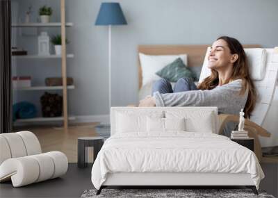 Woman relaxing in cozy chair at home. Female portrait. Wall mural