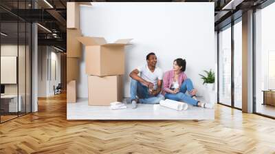 Young couple in a new house planning decoration moving home. Wall mural