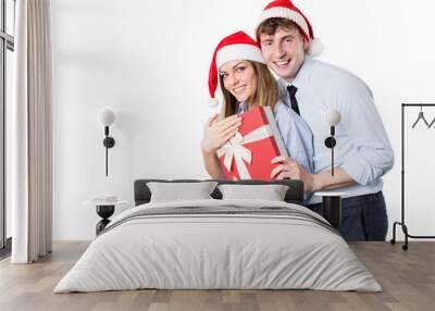 Young happy couple in Santa hat with gift boxes. Wall mural