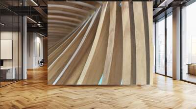 Looking up at the backside of a wood carved bench made of planks of beige wood Wall mural