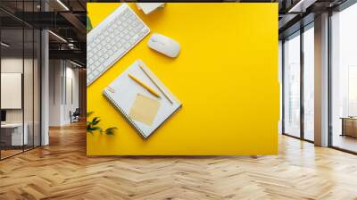 Office desk workspace on bright color yellow background. Office table Work space layout with computer keyboard, plant mouse notepad notes and copy space. Top view office table with palm plant. Wall mural