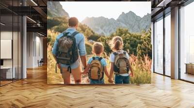 A man and two children are walking through a forest with backpacks on Wall mural