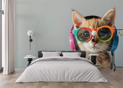 A stylish cat wearing colorful sunglasses and headphones against a plain background, representing a fun and trendy pet concept with ample copy space. Wall mural