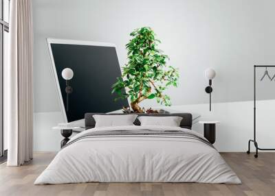 Technology fuels growth. Studio shot of a bonsai tree growing out from a laptop in studio against a grey background. Wall mural