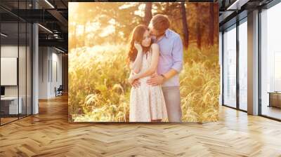 young couple in love at sunset at the field Wall mural