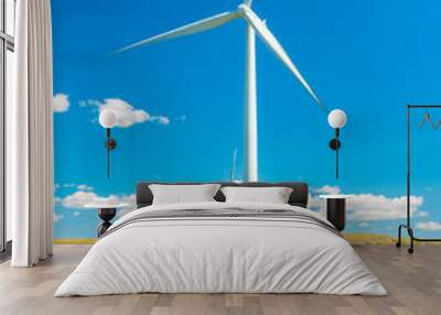 Wind turbine in a summer farm field under a hot blue sky Wall mural