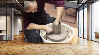 Artist makes clay pottery on a spin wheel Wall mural