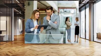 Business couple holding digital tablet and discussing company strategy Wall mural