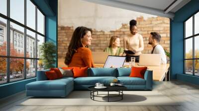 Business woman working on laptop with her young multiethnic startup team in the modern office Wall mural