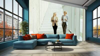 Business women walking in the office corridor Wall mural