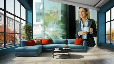 Businesswoman enjoys a coffee break in a modern office building on a sunny day Wall mural