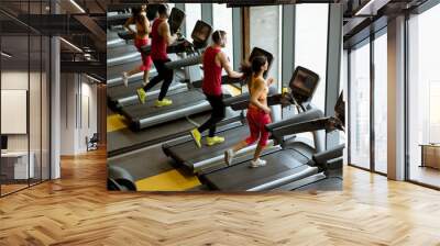 Couple run on treadmills in the gym Wall mural