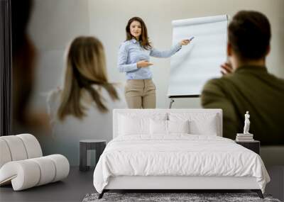 Creative positive female leader talking about business plan with students during workshop Wall mural