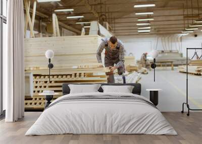 Disabled young man with an artificial leg is working at the furniture  factory Wall mural