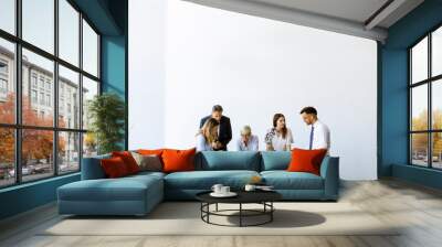 Group of business people with young adults and senior woman colleague on meeting at modern bright office interior Wall mural