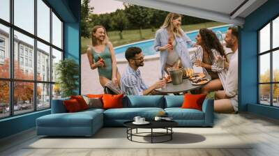 Group of young people cheering with cider by the pool in the garden Wall mural