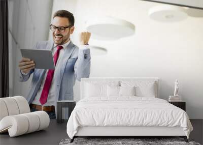 Happy businessman with tablet in office Wall mural