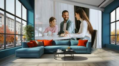 happy young famila eat cakes and drink tea together Wall mural