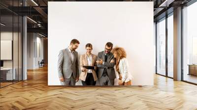 Multiethnic business people using digital tablet while standing by the wall in the office Wall mural