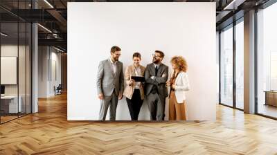 Multiethnic business people using digital tablet while standing by the wall in the office Wall mural