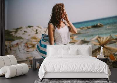 Pretty young woman with a bag on the beach Wall mural