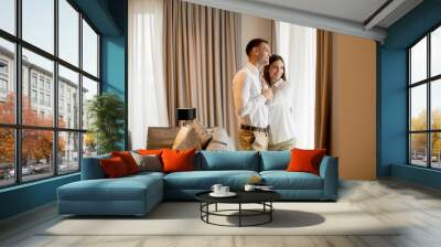 Romantic happy young couple relax at modern home interior Wall mural