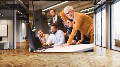 Senior businesswoman working together with young business people in office Wall mural