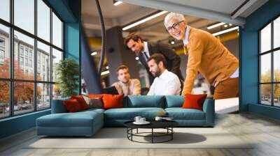 Senior businesswoman working together with young business people in office Wall mural