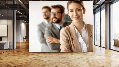 Smiling young business woman standing with group of corporate colleagues in a row together Wall mural